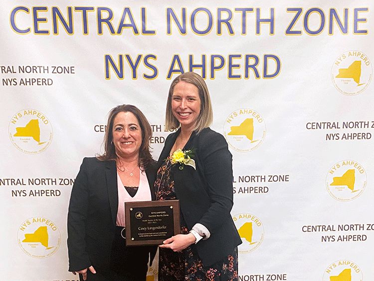 Two adults standing together holding a plaque.