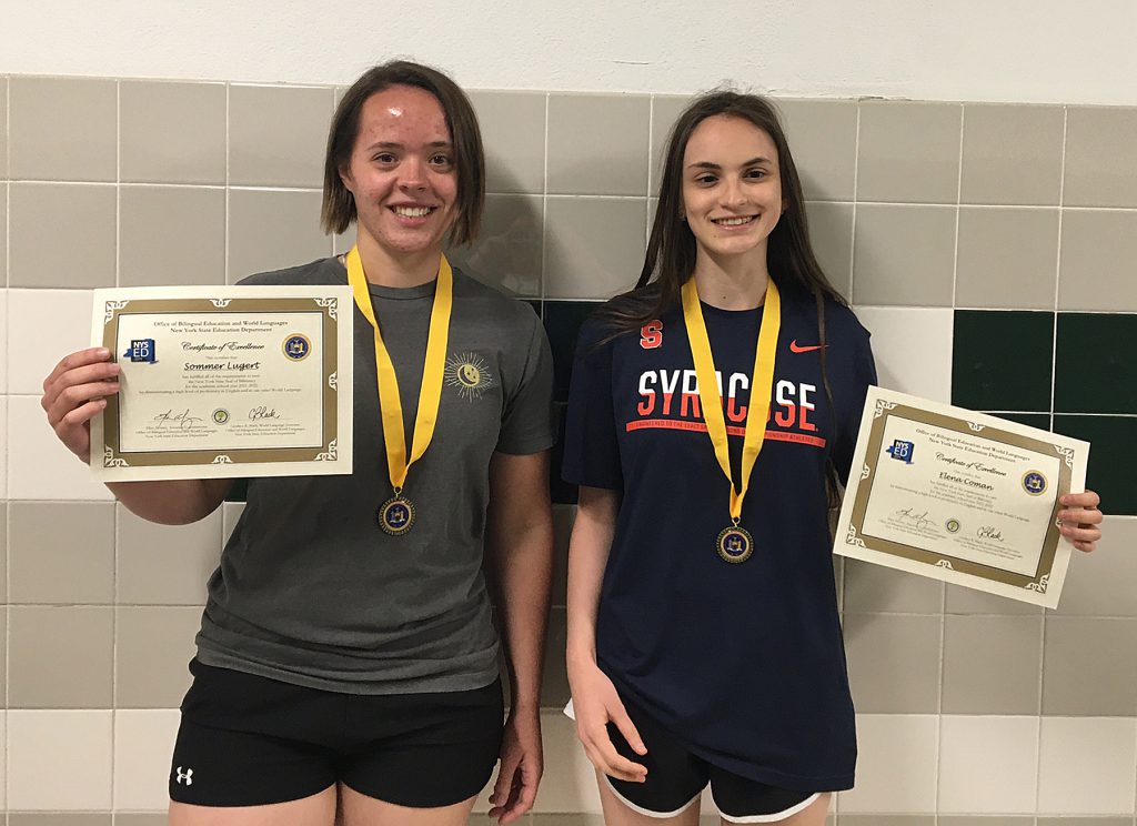 Two students standing, holding certificates.