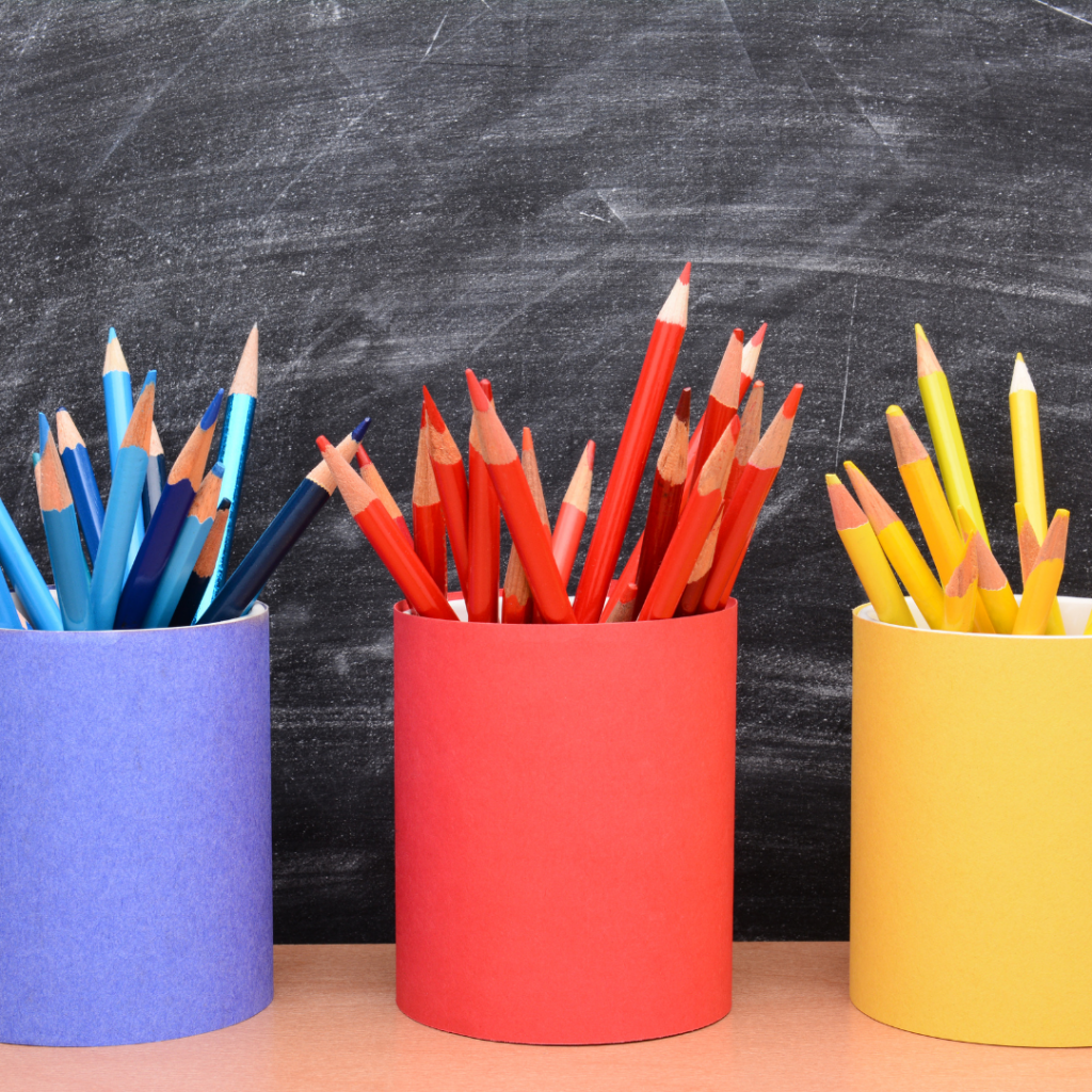 This is an image of a chalkboard in the background and cups of pencils