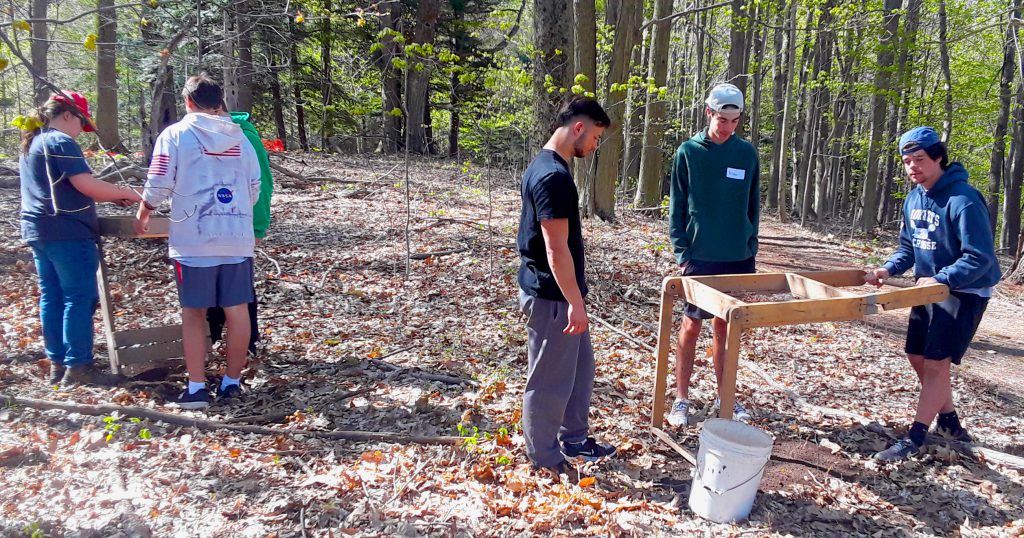 This is an image of several high school students using screening tools during an excavation