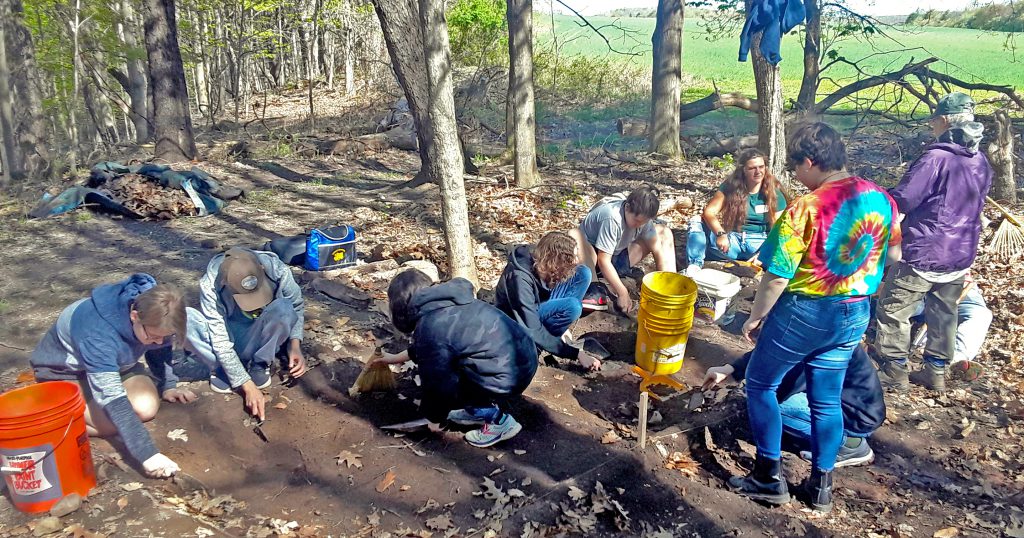 This is an image of several students digging in the dirt during an excavation