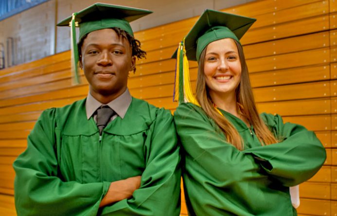 Two students standing together at graduation.