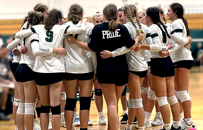 Several volleyball players huddling together during a volleyball game.