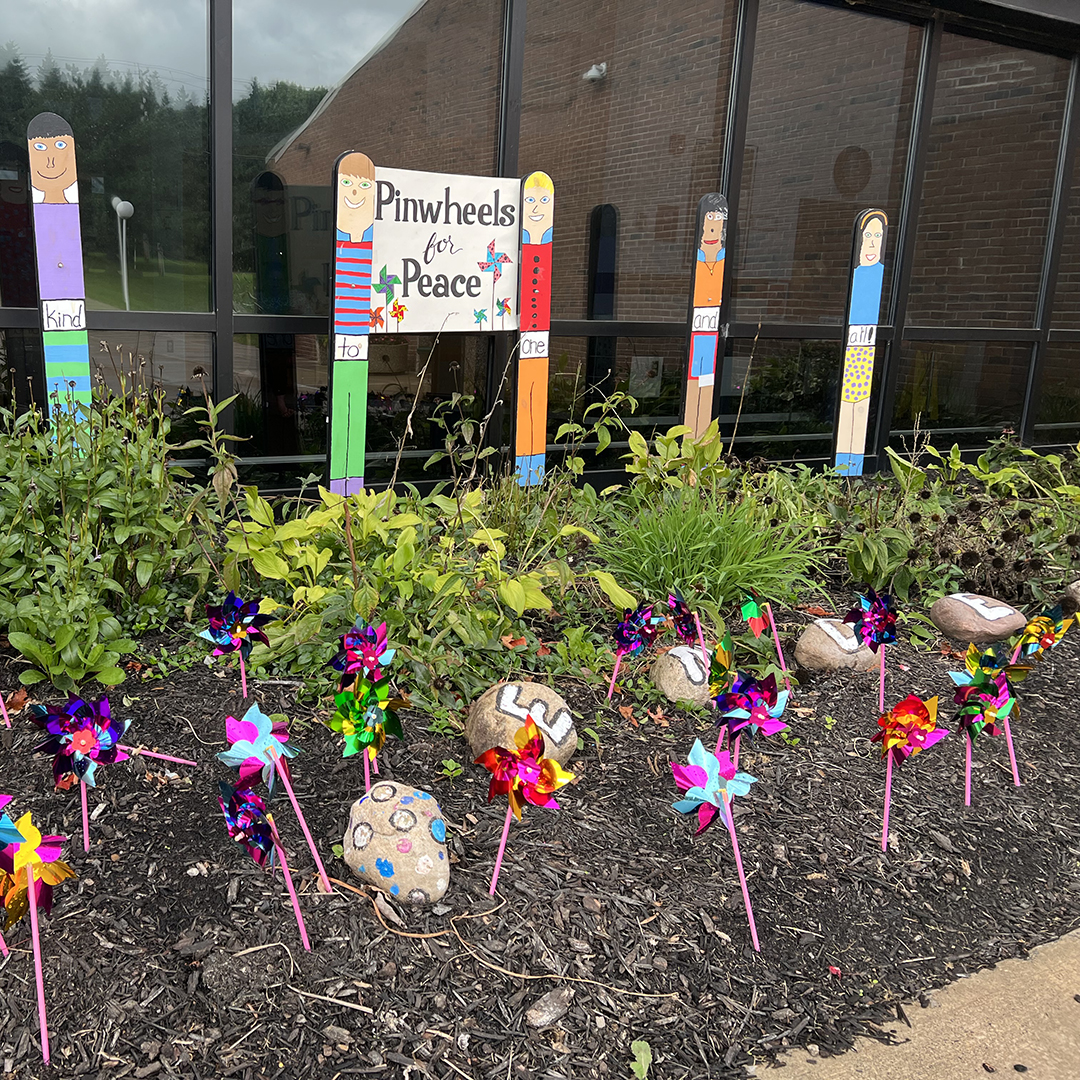 Colorful pinwheels are on display in front of an elementary school building