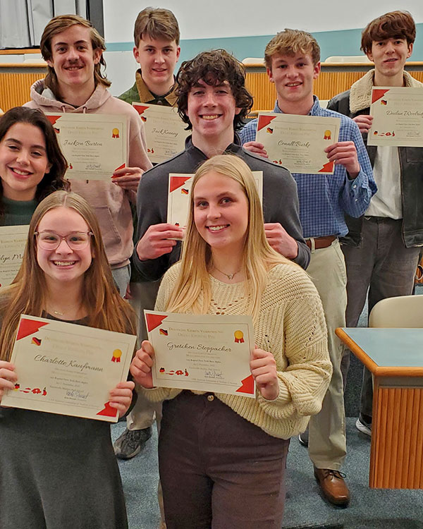 Several high school students who study German stand together for a photo