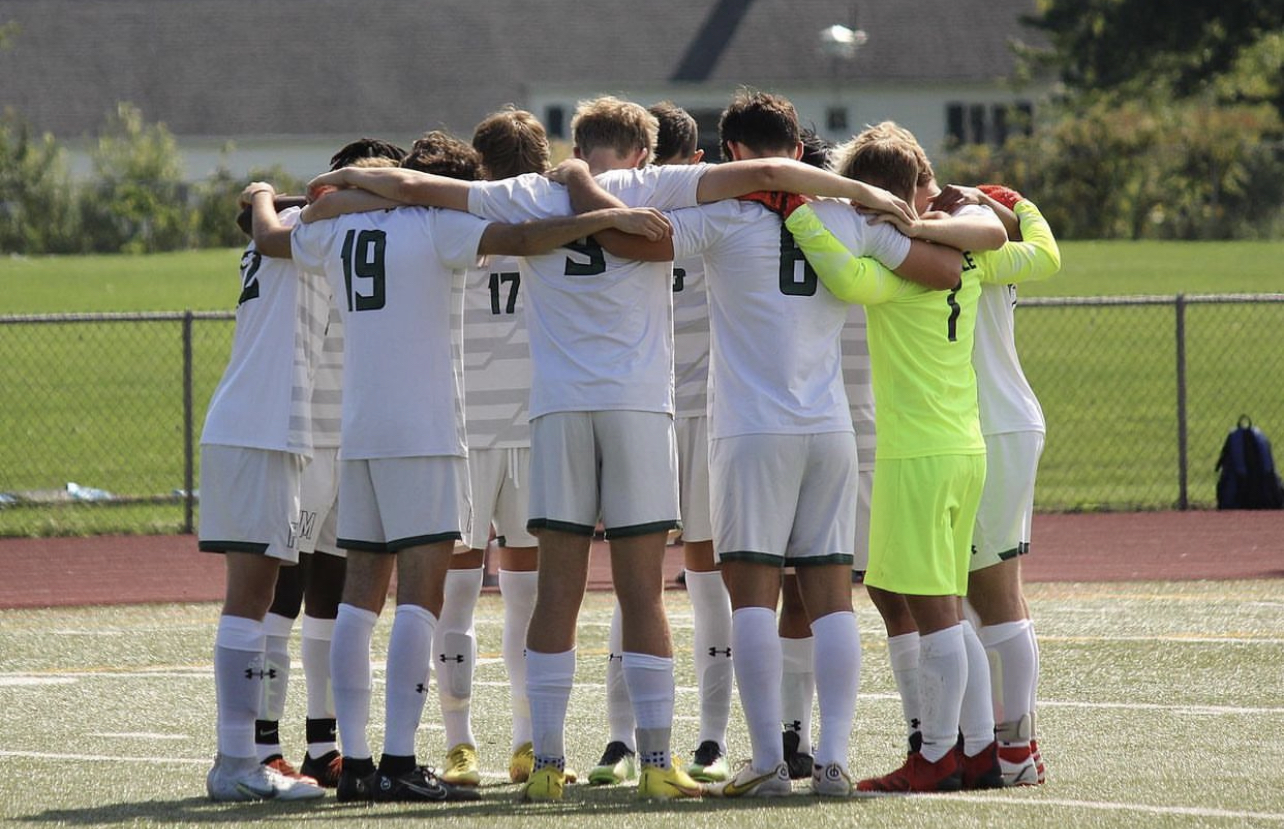 Members of the F-M boys varsity soccer team huddle together on the soccer field
