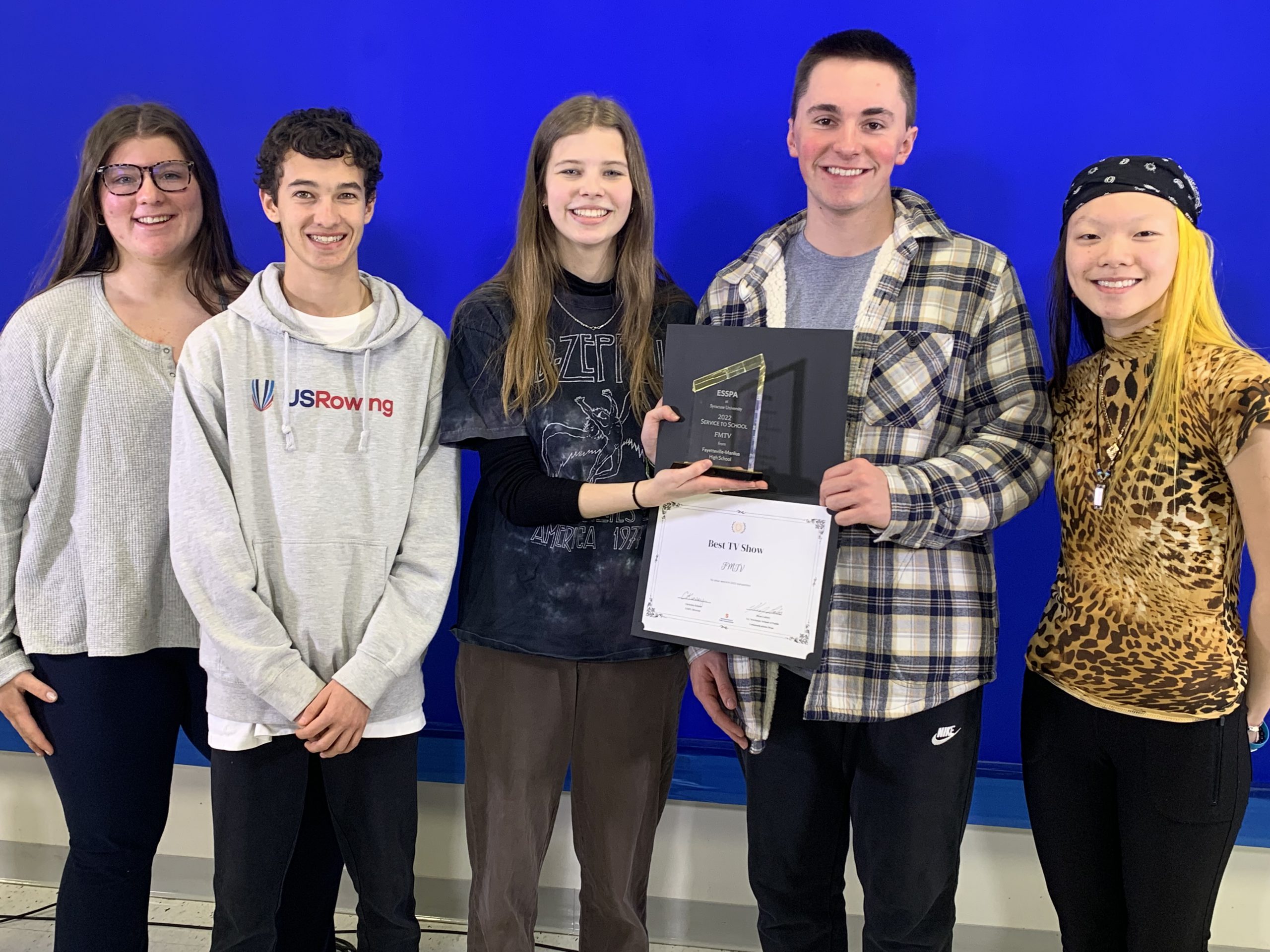 Five high school students stand together for a photo. One of them is holding an award, and another student is holding a certificate.