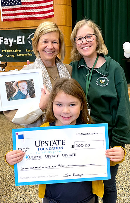 Fayetteville Elementary School student stands next to Principal Eileen Lux and Upstate University Hospital Professor of Pediatrics Irene Cherrick, MD