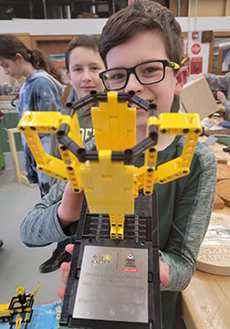 A Wellwood student holds the trophy that the robotics team won