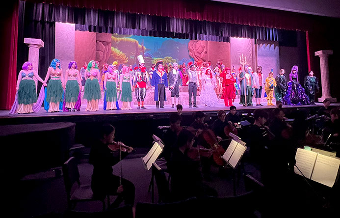 F-M High School students stand on stage during a performance of The Little Mermaid