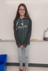 Catie standing in front of a whiteboard posing for the camera.