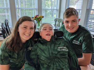 Three people, in F-M green colors, pose for a photo