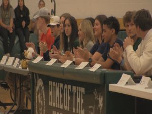 A group of student-athletes clapping after signing National Letters of Intent.