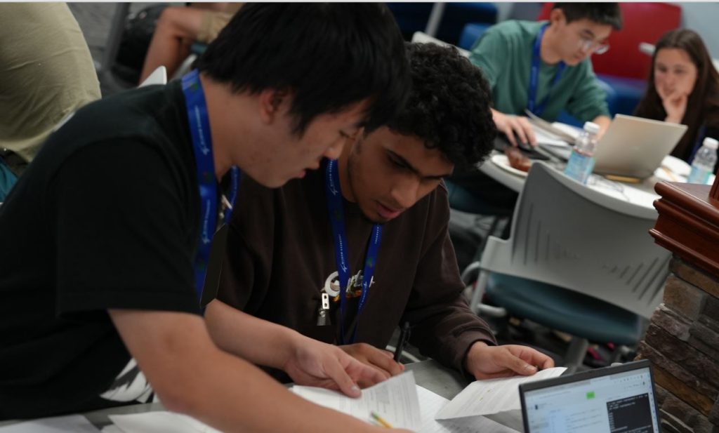 Two senior team members work on a problem during the code quest event