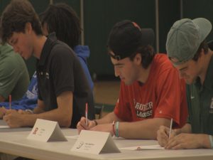 Close-up of a few students singing National Letters of Intent.