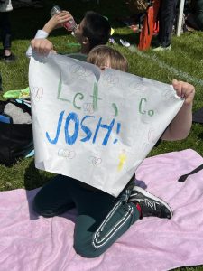An onlooker at the Special Olympics holds up a "Let's Go Josh" sign