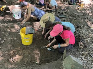 F-M students uncover pieces of rock and charcoal during an archaeology dig in July, 2023.