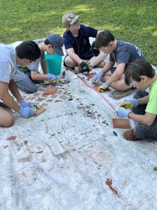 Students work on Knapping during Archaeology Camp week in July, 2023.