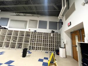 More garbage cans are used to collect dripping water from a high school music classroom’s ceiling due to failing patches in the roof.