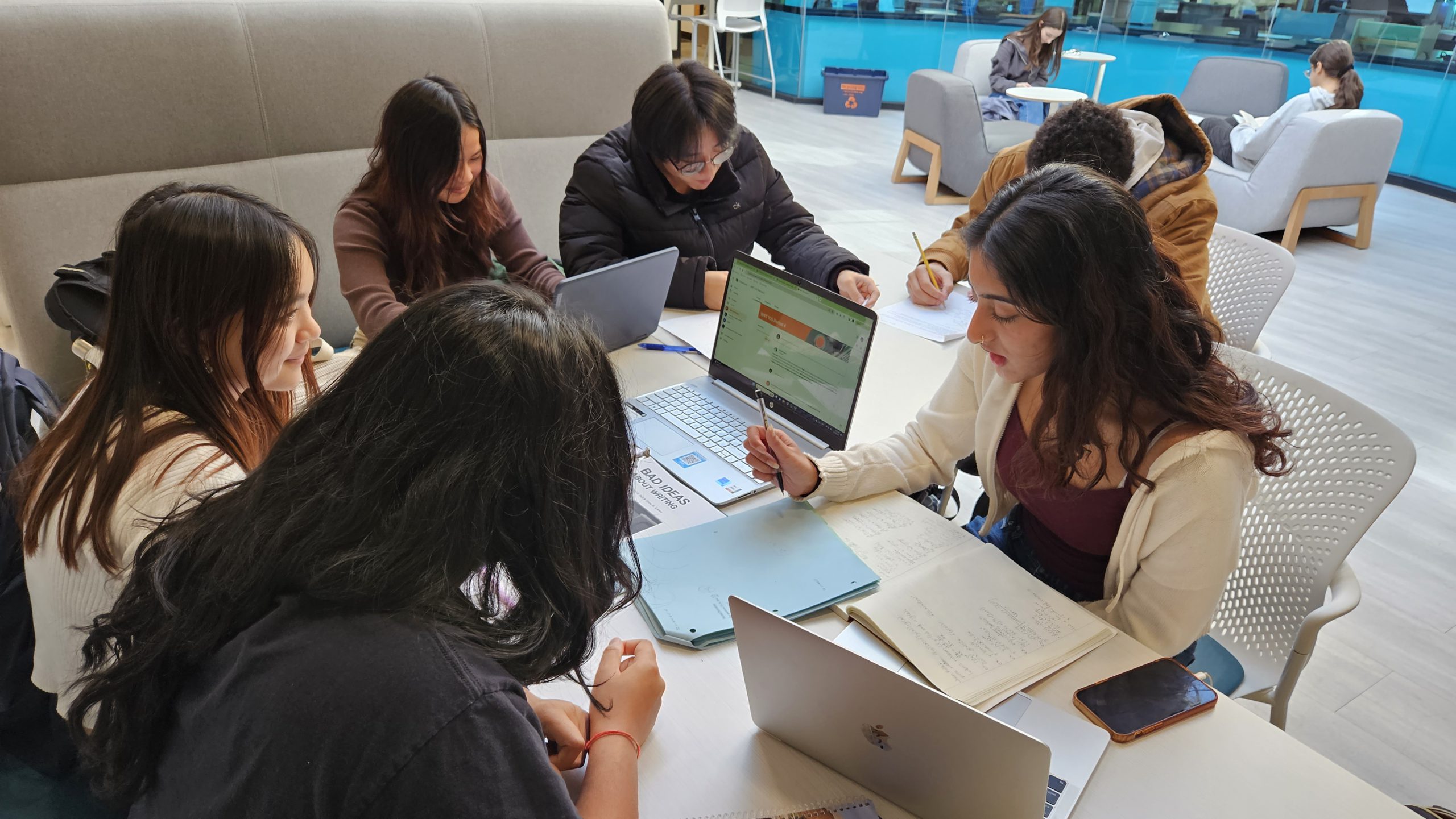 Several high school students work together with laptops.