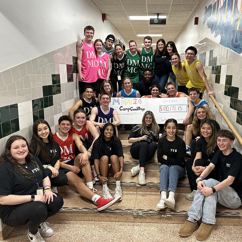 Many high school students gathered together with a faux check to Camp Good Days for $100,171.15.