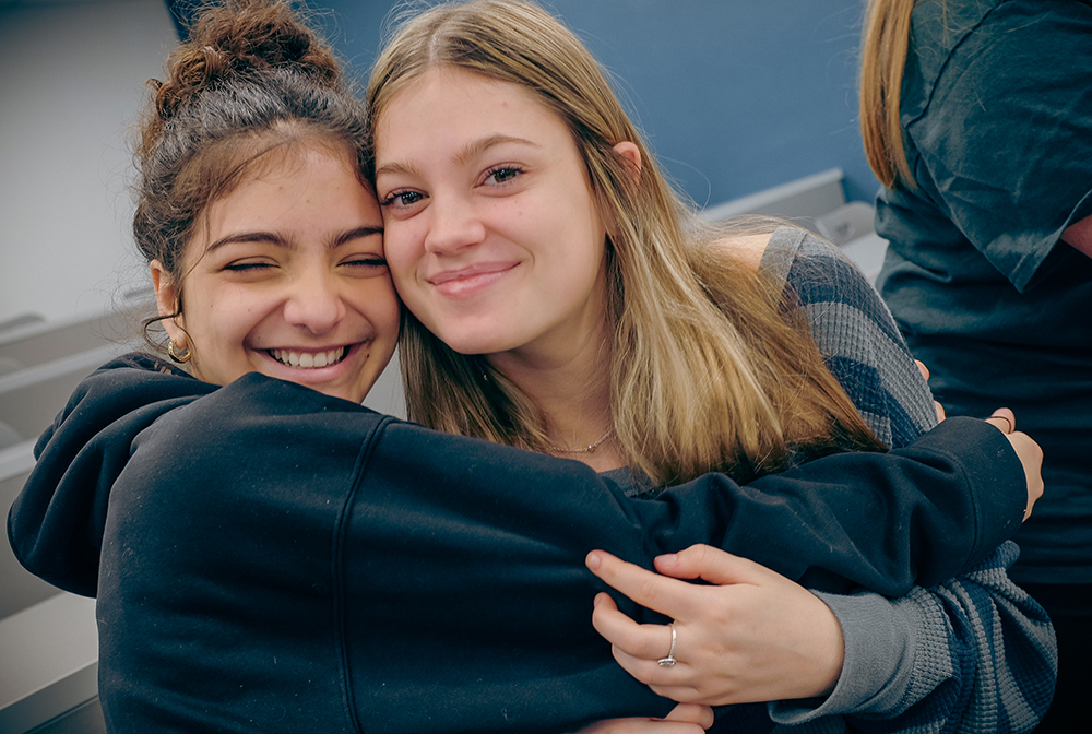 Two girls embrace.