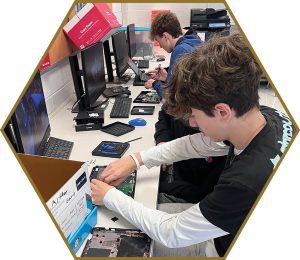 Two high school students repairing dismantled chromebooks.
