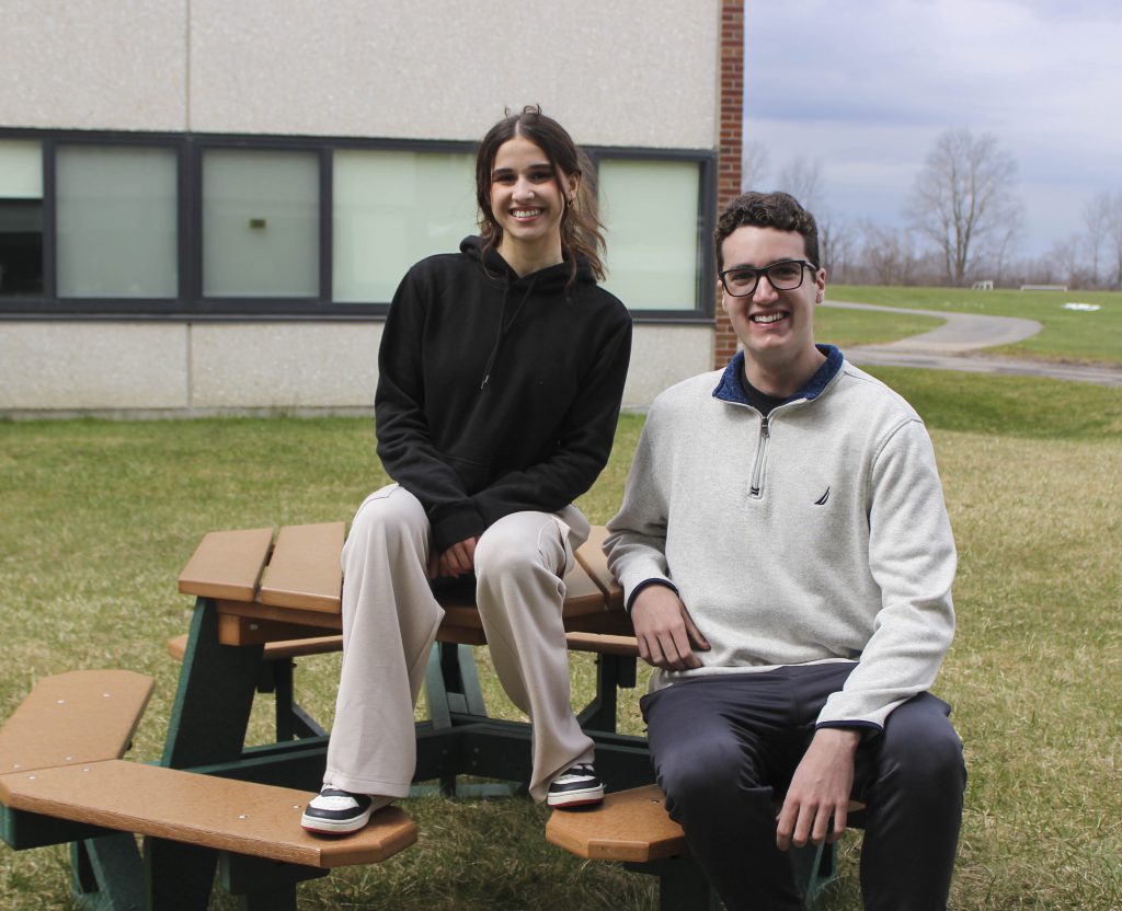 Two FMHS students sit on a picnic table outside of the high school.