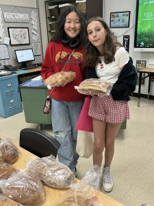 Eagle Hill students hold up fresh-baked loaves of bread.