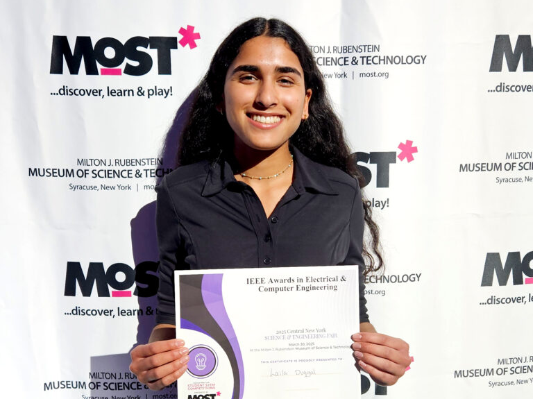 FMHS student Laila Duggal holds close a certificate at the CNY Science and Engineering Fair.