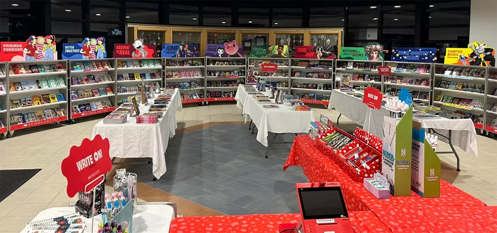 A large room filled with tables and shelves displaying book sale offerings.