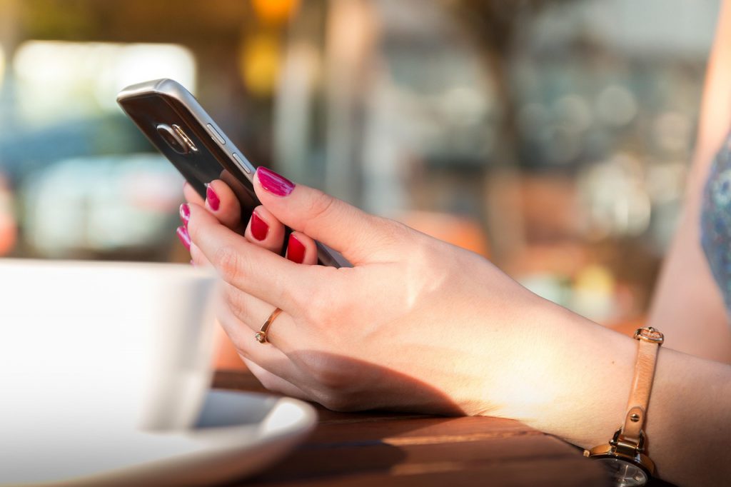 Closeup of hands cradling a smartphone.