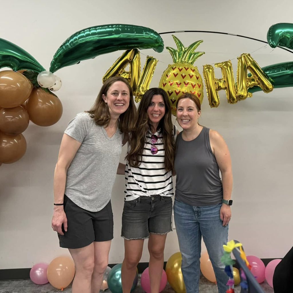 Three HSA parents gather with Aloha party balloons.