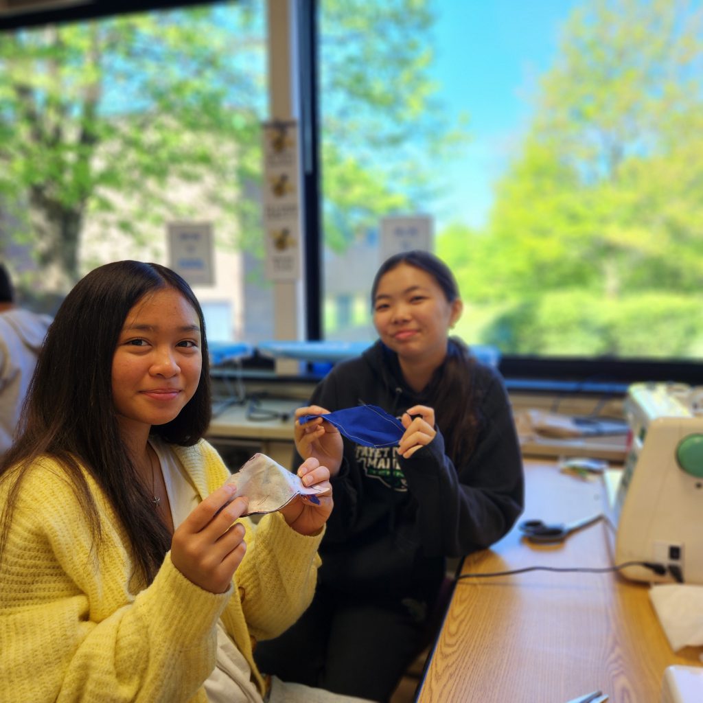 Two students hold up fabric birds.