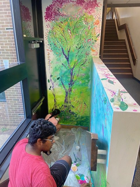 Students painting mural in stainwell.
