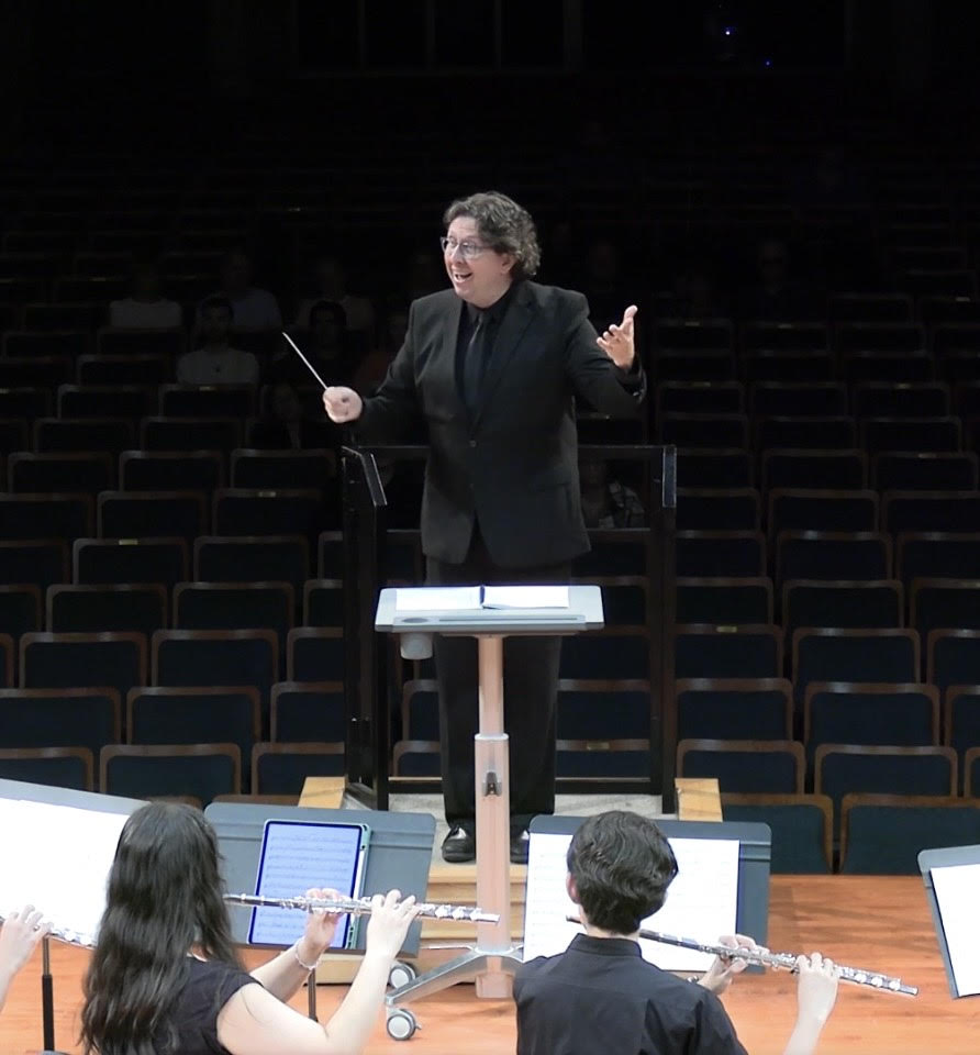 Eagle Hill Middle School music teacher John Jeanneret conducts musicians.