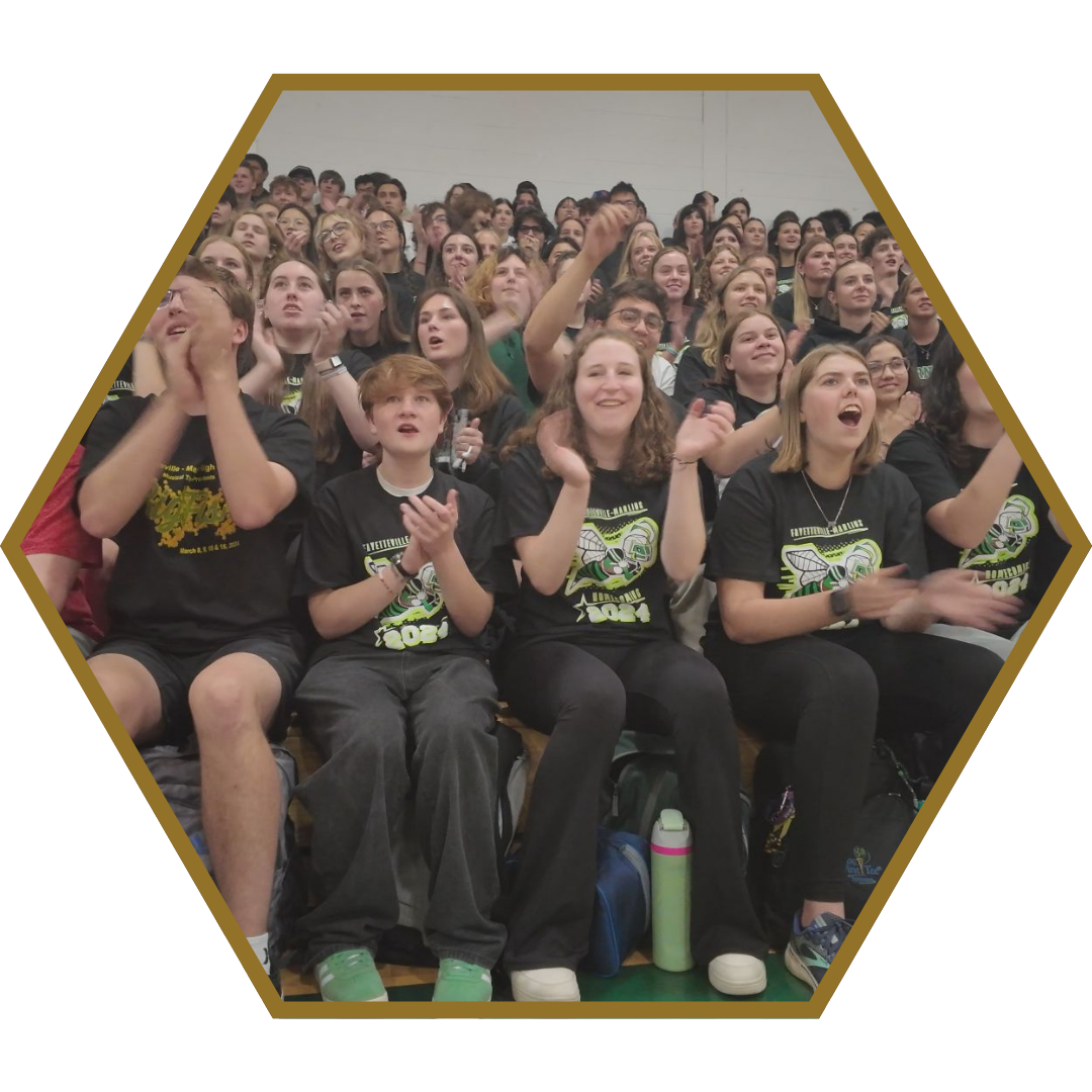 students sitting on gym bleachers cheering