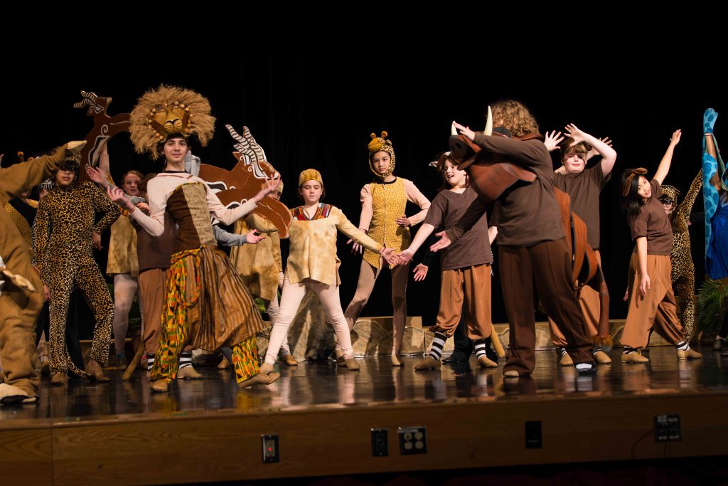 Students perform scene from The Lion King Jr. in costume.