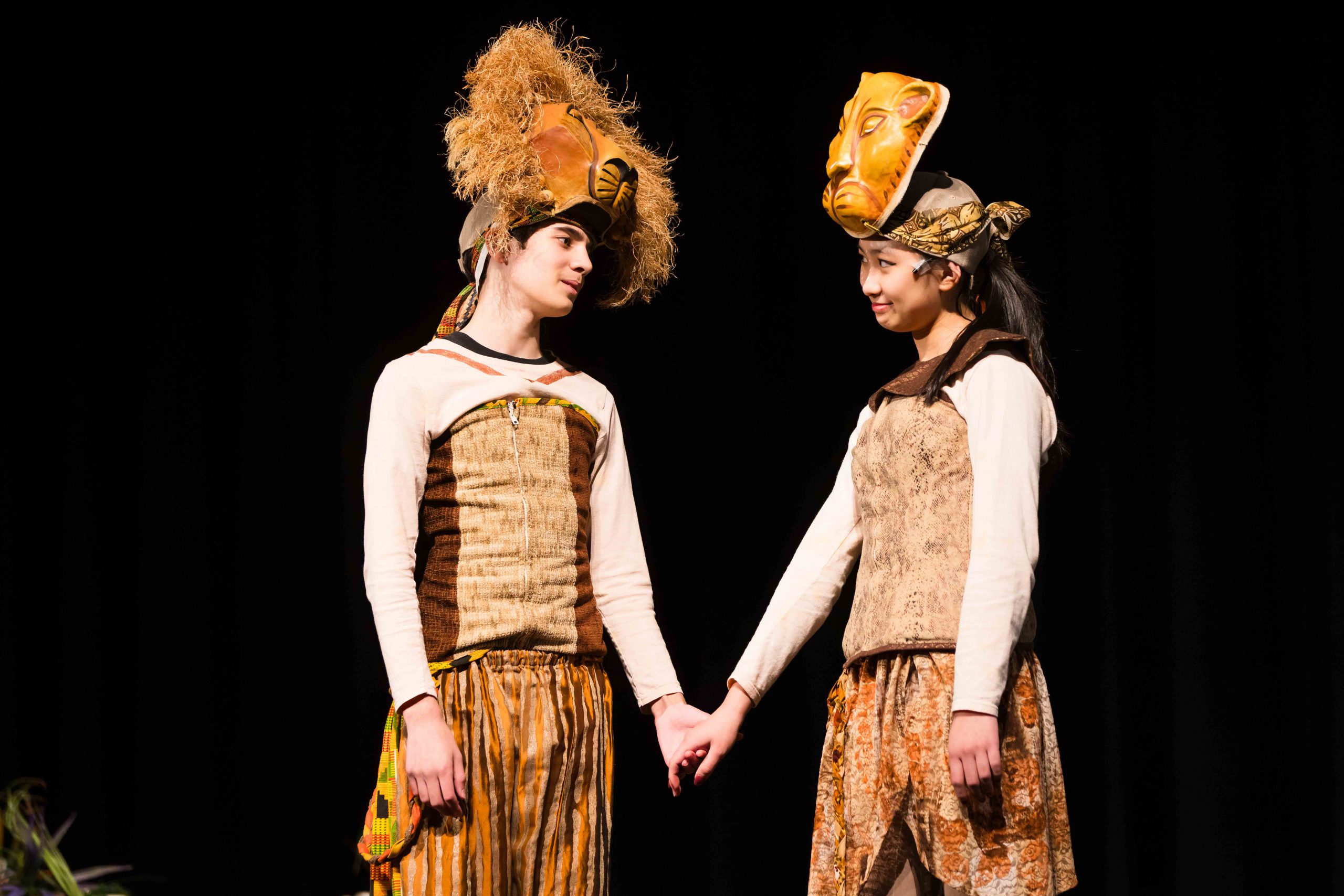 Two students in lion costumes perform on stage during The Lion King Jr. 