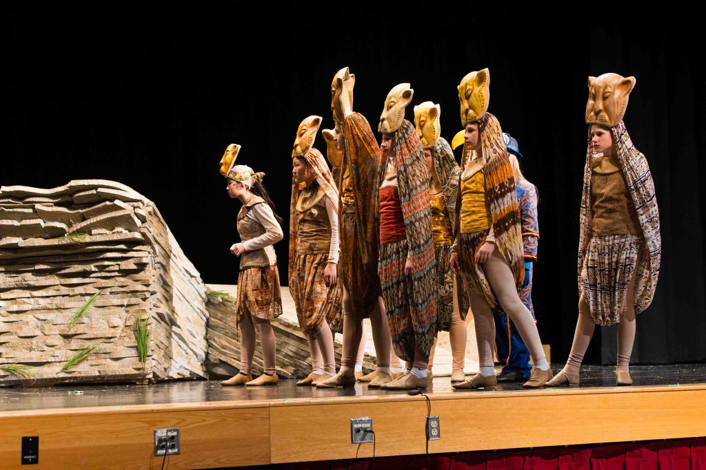 Students perform scene from The Lion King Jr. in costume.