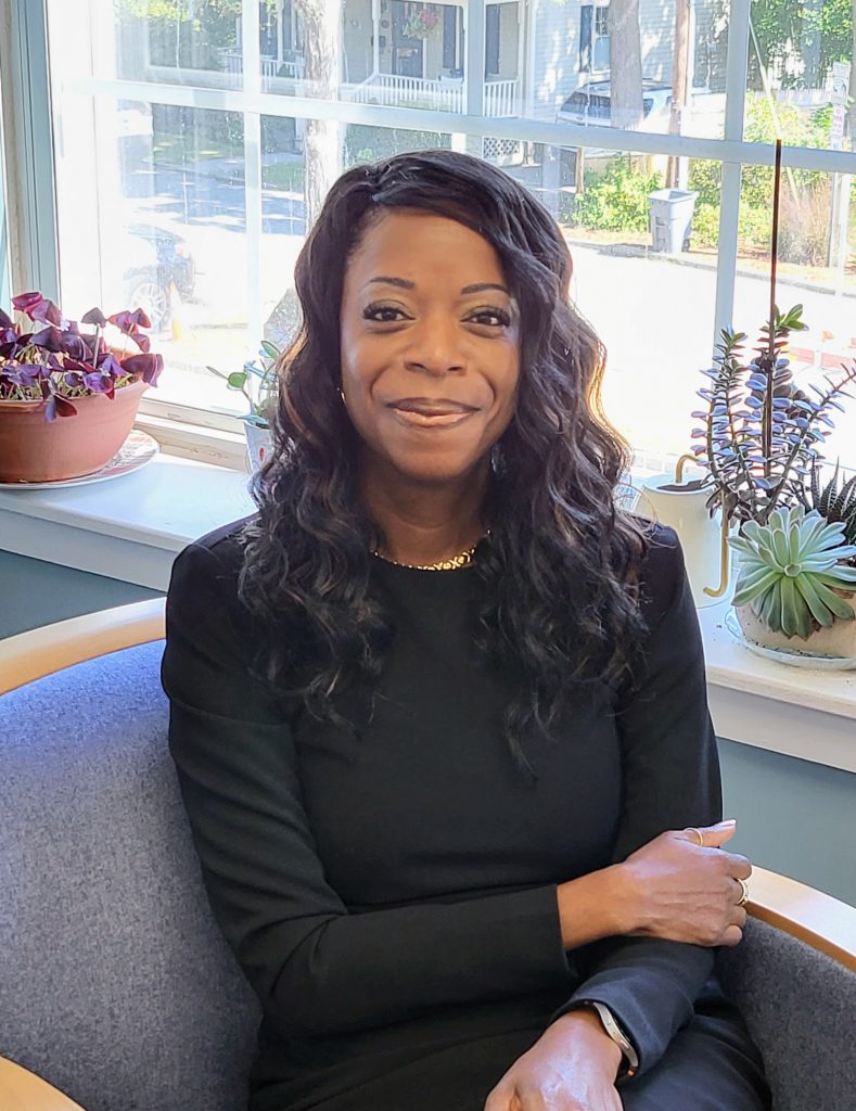 Woman seated, looking directly at the camera, smiling
