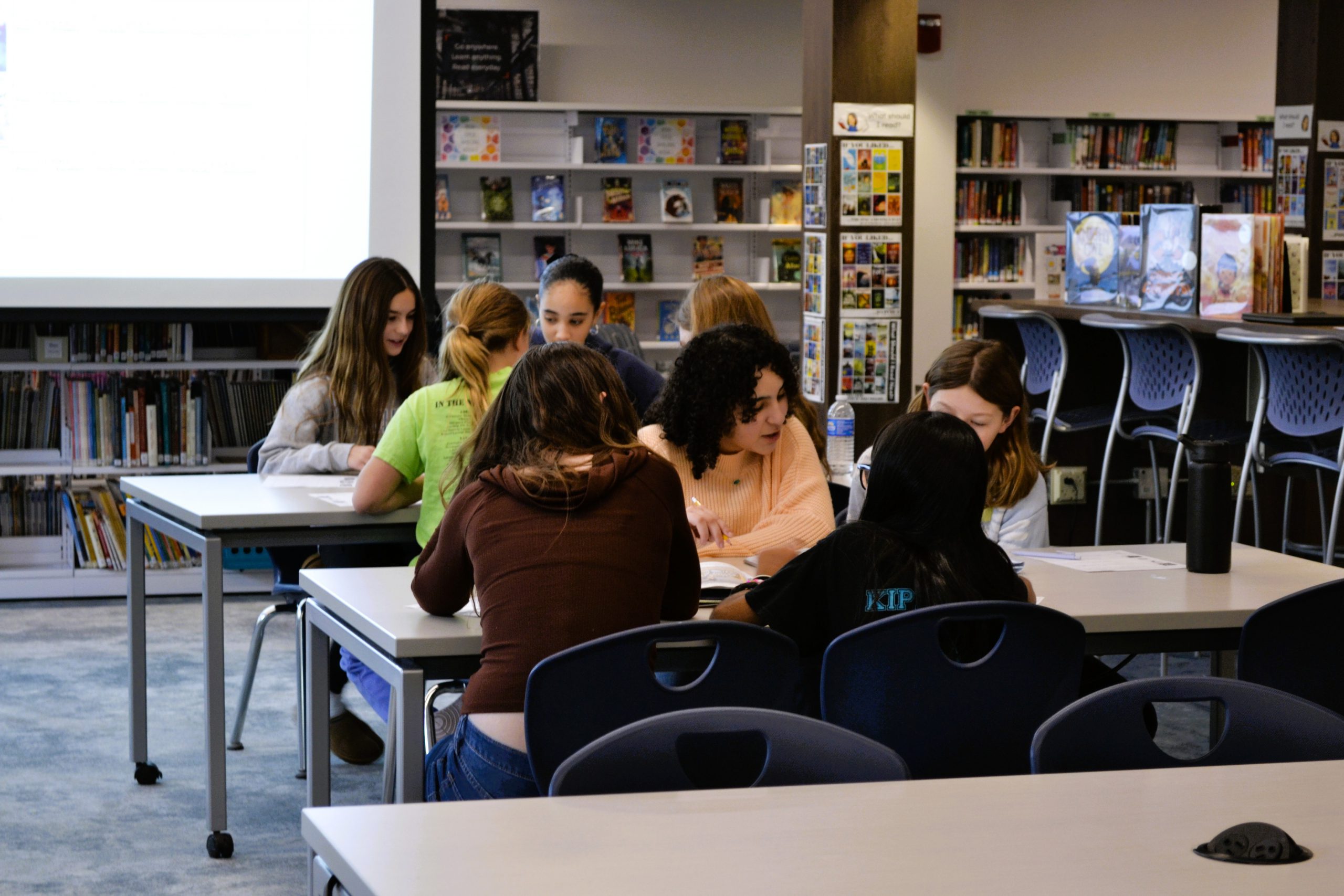 Students sit at desks in library.