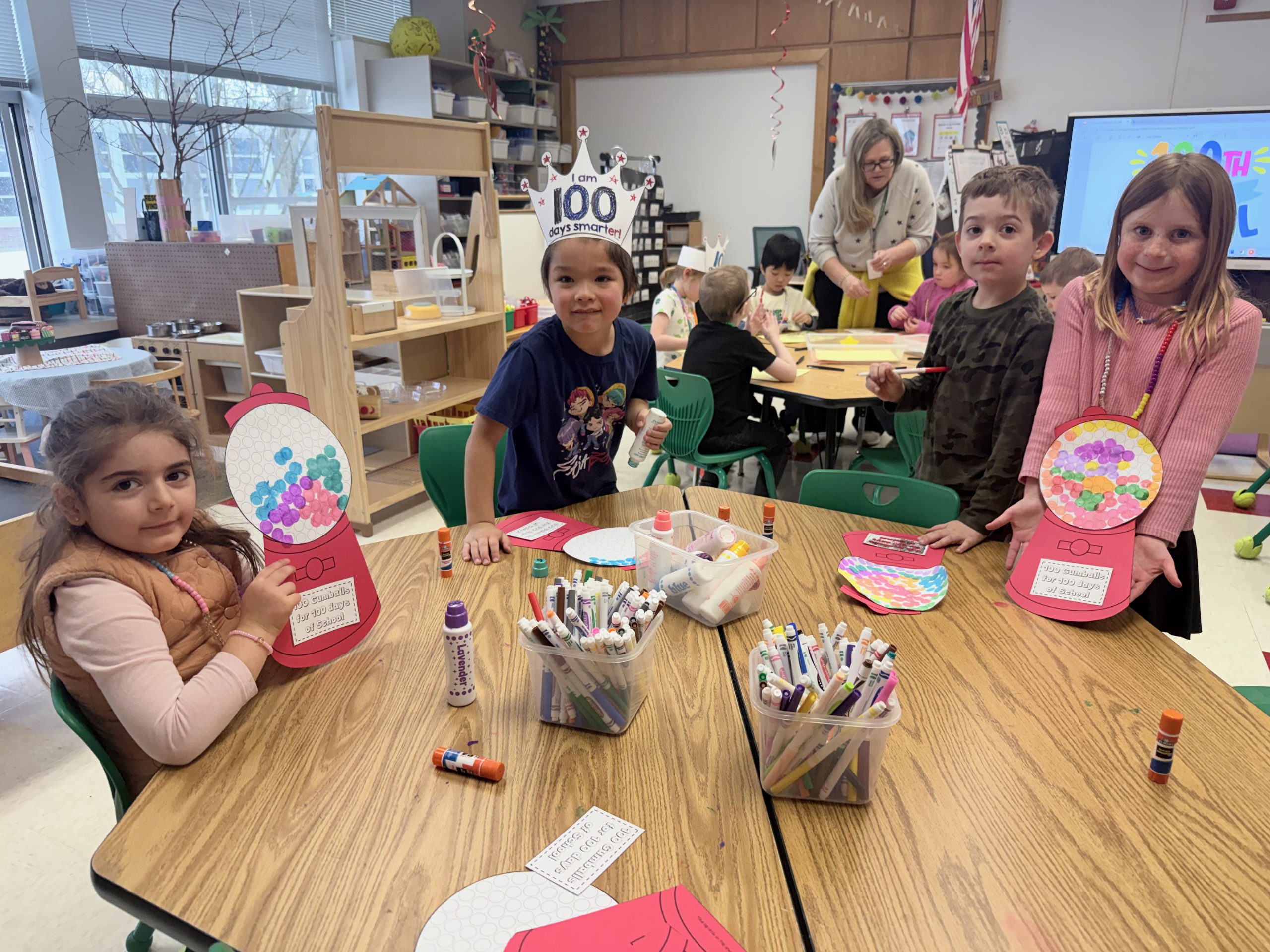 Students sit at table wearing 100 days of school hats.