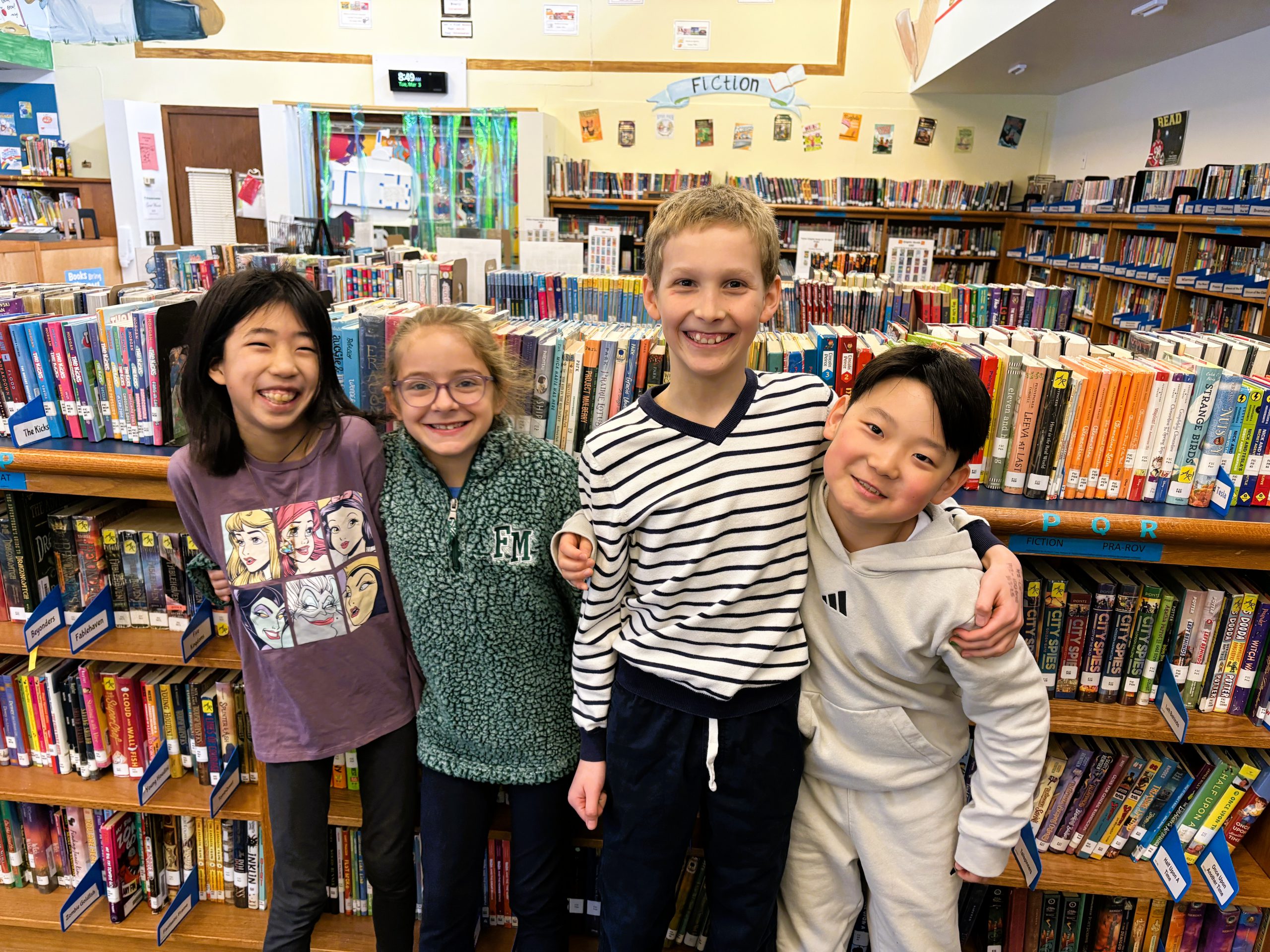 Four Enders Road students pose for photo in library.