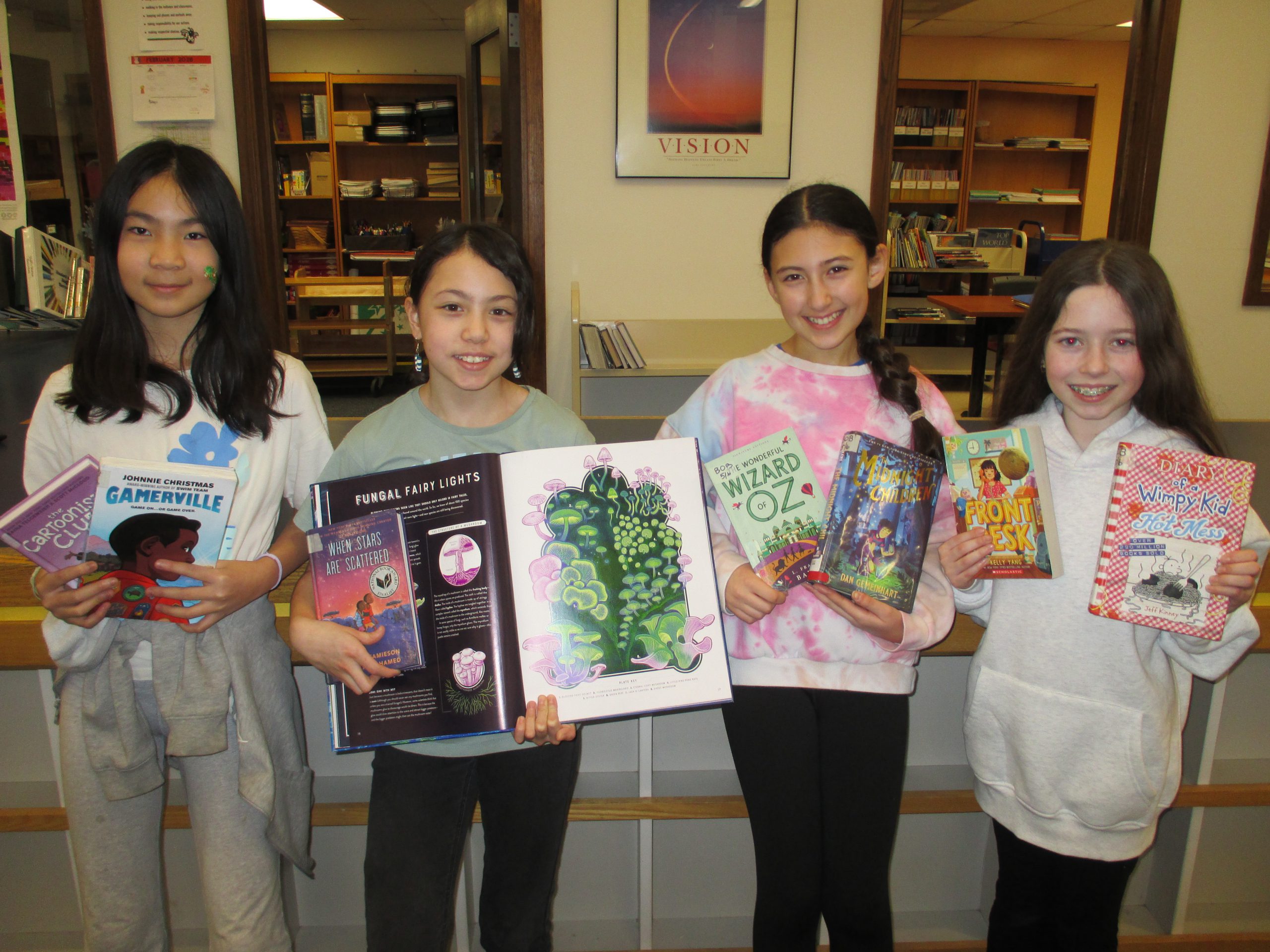 Eagle Hill Battle of the Books team smiles at camera while holding books.