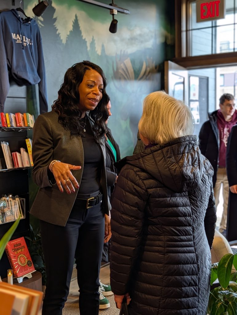 Dr. Parvey speaks with woman at meet and greet at book shop.
