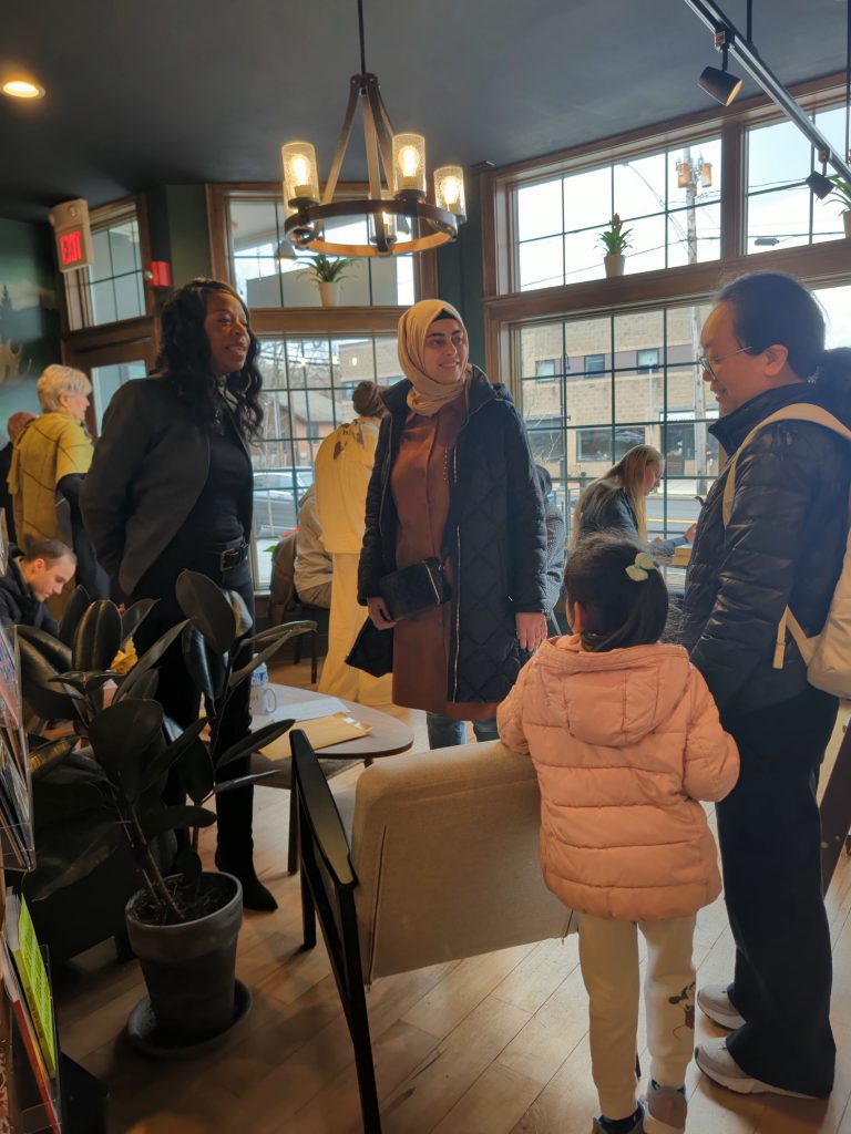 Dr. Parvey speaks with mother, daughter, and community member in book shop.