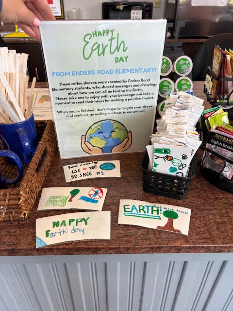 Earth Day sign and student designed coffee sleeves at local business.