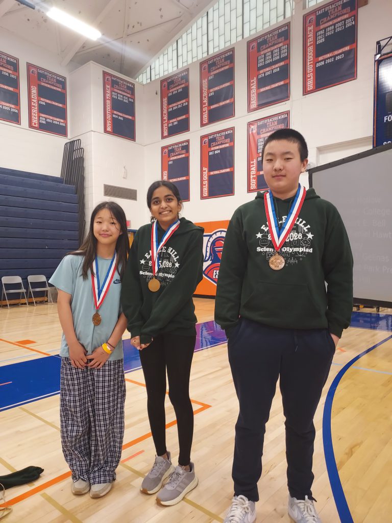 Three students standing wearing medals