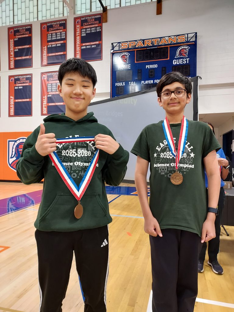 Two students standing wearing medals